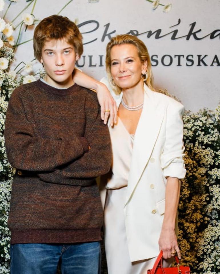 Юлия Высоцкая с сыном Петром стоит на баннере