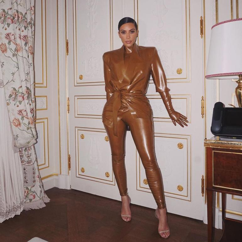 Ким Кардашьян в латексе стоит в комнате
