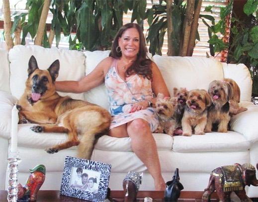 Сузана сидит на диване с собаками
