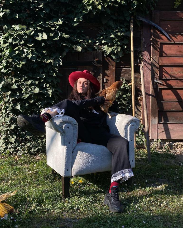 Alina Pash сидит на кресле в саду