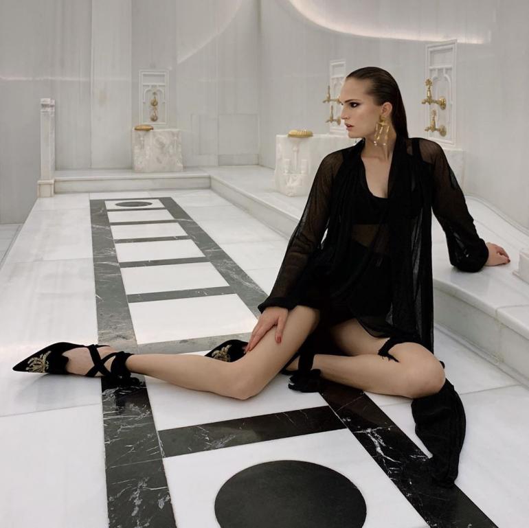 Алла Костромичева в черном платье сидит на полу