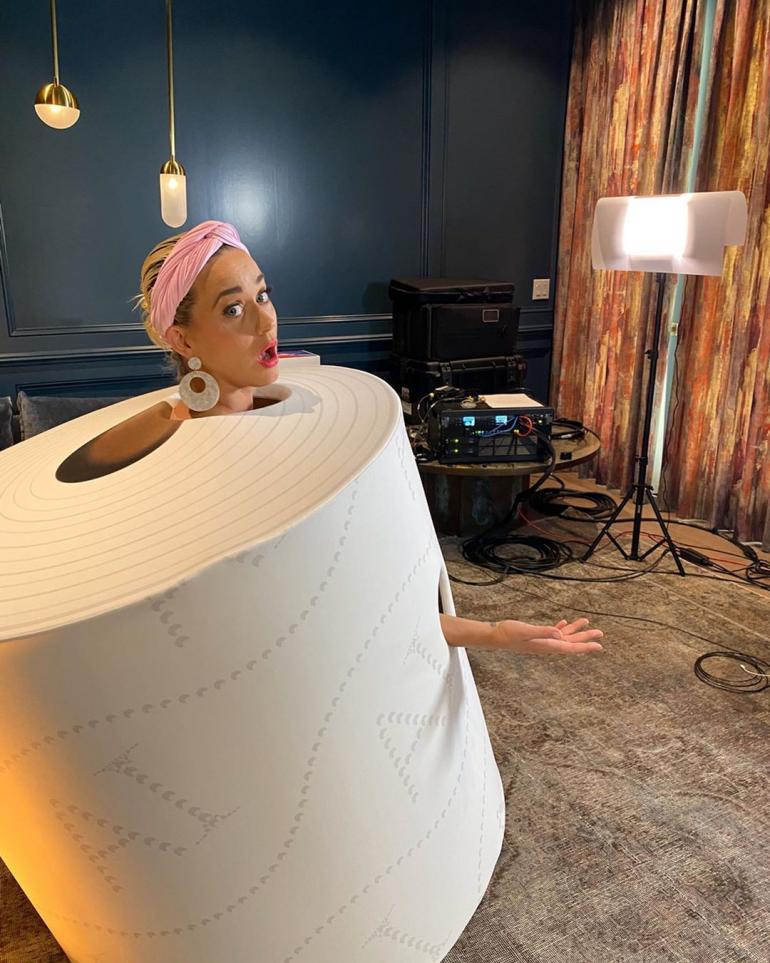 Беременная Кэти Перри в костюме рулона туалетной бумаги в комнате