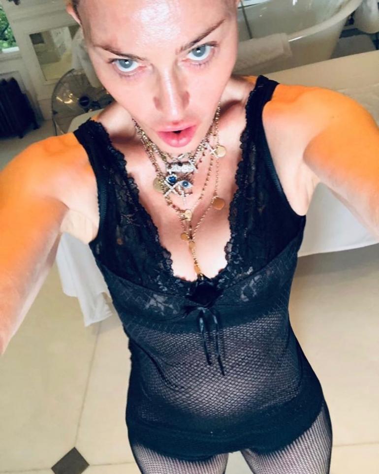 Мадонна стоит в черном боди