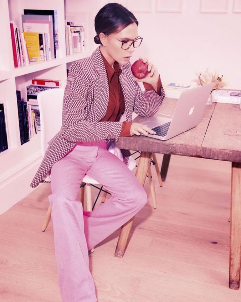 Виктория Бекхэм сидит за столом с ноутбуком