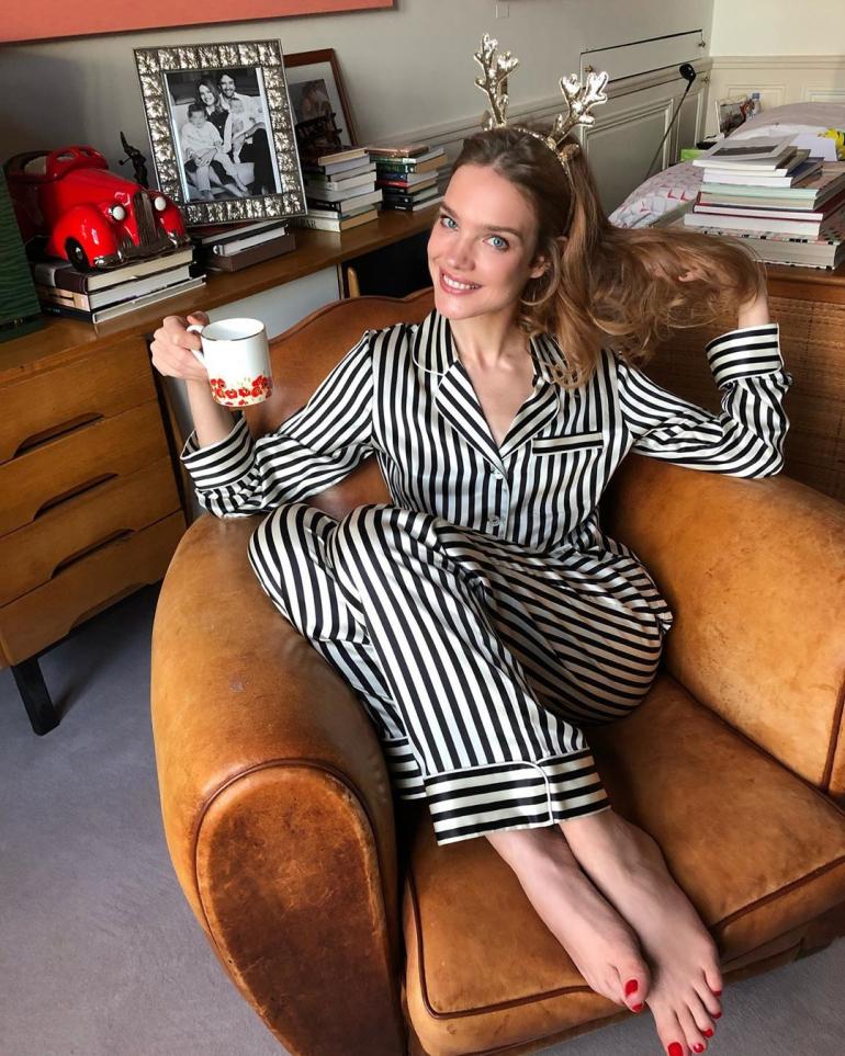 Наталья Водянова  сидит в пижаме в кресле в комнате