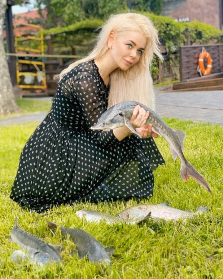 Алина Гросу на лужайке с рыбой