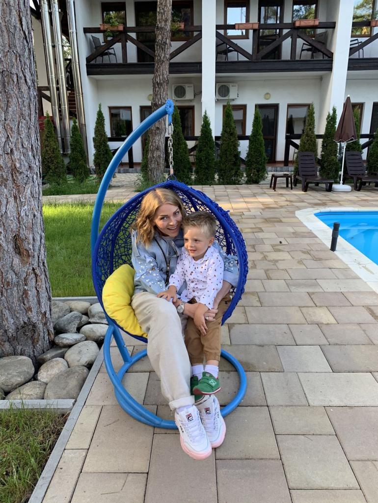 Яна Глущенко с сыном сидит в саду
