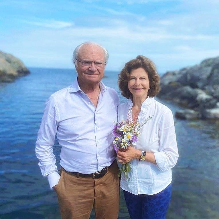 Король и королева Швеции стоят у моря