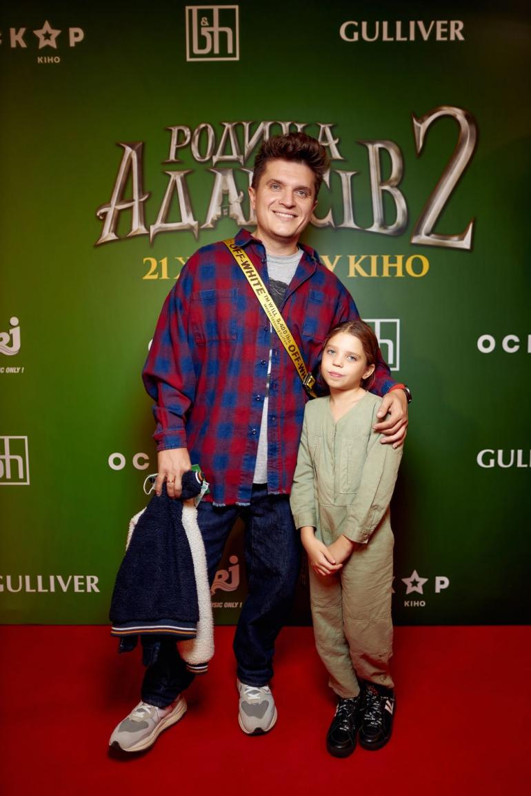 Анатолий Анатолич с дочкой стоит на фоне постера