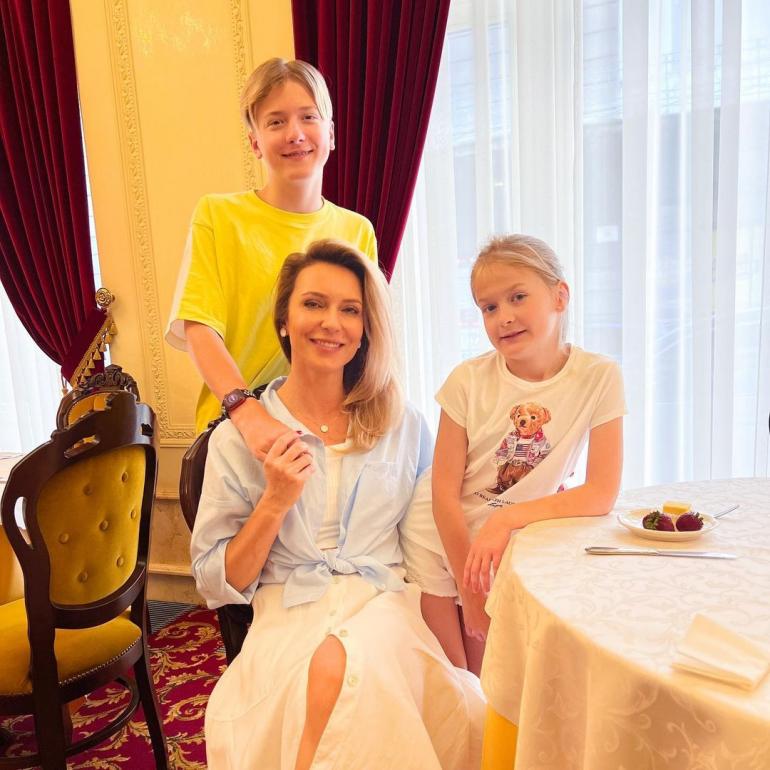 Марина Боржемська сидить за столом з дітьми