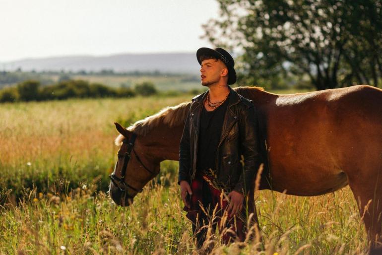 Сергій Лазановський стоїть у полі біля коня