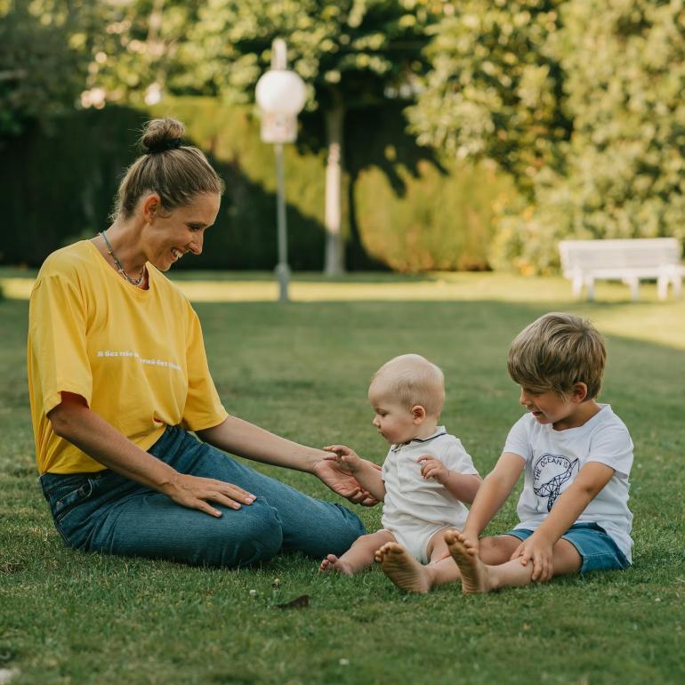 Катя Осадча з синами сидить на галявині