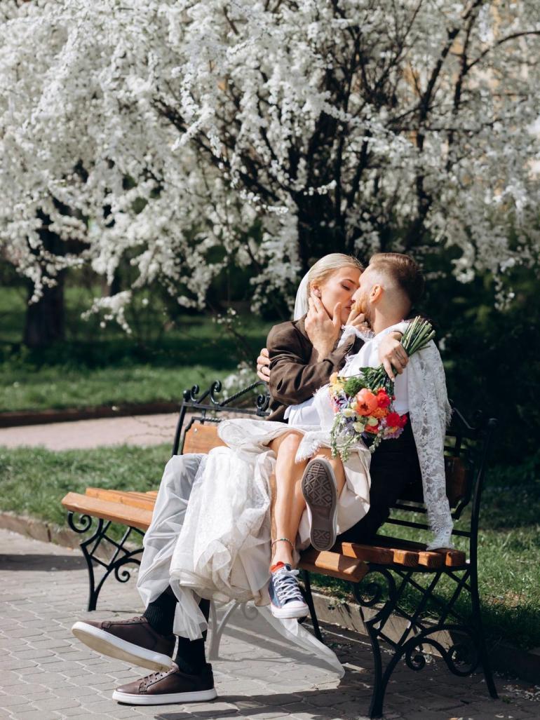 Павло Вишебаба та Анжеліка Кравець сидять на лавочці у парку