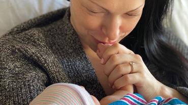 Лора Препон целует руку младенца