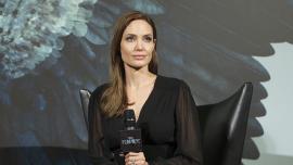 Анджелина Джоли сидит в черном платье